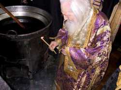 Патриарх Сербский Павел разжигает огонь для мироваренной печи.  Белград, 6 апреля 2004 г.